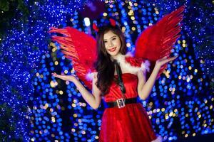 jolie asiatique fille dans Père Noël costume pour Noël avec nuit lumière photo