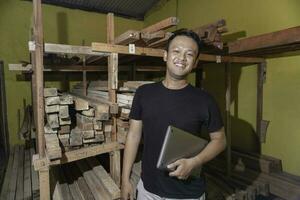 Beau asiatique homme est souriant tandis que vérification le sien charpenterie atelier photo