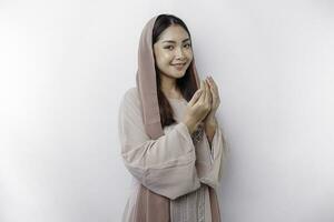 religieux magnifique asiatique musulman fille portant une foulard prier à Dieu, isolé par blanc Contexte photo