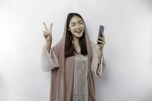 excité asiatique musulman femme portant une tête écharpe donnant nombre 123 par main geste photo