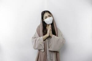 portrait de une Jeune magnifique asiatique musulman femme portant une masque et foulard faire des gestes eid mubarak salutation pendant pandémie photo