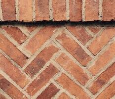 vieux brique mur texture arrière-plan, extérieur Anglais patrimoine bâtiment grunge rouge mur de pierre façade avec endommagé plâtre. abstrait fissure mur surface toile de fond dans ancien tons photo