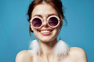 émotif femme portant des lunettes de soleil duveteux des boucles d'oreilles bijoux fermer bleu Contexte photo