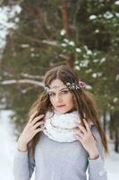 magnifique la mariée dans une blanc robe avec une bouquet dans une couvert de neige hiver forêt. portrait de le la mariée dans la nature. photo