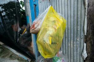 Jaune Plastique Sacs contenant Ménage cuisine déchets étaient accroché sur le clôture. photo