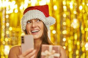 femme plus de or Contexte dans Père Noël claus chapeau avec téléphone photo