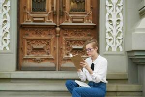 jolie femme avec une livre dans le sien mains en plein air en train de lire la communication photo