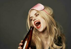 ivre femme avec une bouteille de Bière brillant maquillage blond rose masque pour sommeil photo