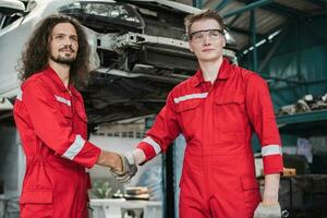 Jeune auto un service mécanique équipe sont discuter le travail et tremblement mains. voiture réparation et entretien concepts photo