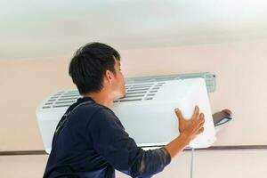 électricien installation air Conditionneur unité, technicien homme installation un air conditionnement dans une client loger, dépanneur fixation air Conditionneur unité, entretien et réparer concepts photo