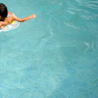 content Indien garçon nager dans une piscine, enfant portant nager costume le long de avec air tube pendant chaud été les vacances, les enfants garçon dans gros nager bassin. photo