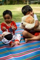 deux content garçons dans société parc, content asiatique frères qui sont souriant Heureusement ensemble. frères jouer en plein air dans été, meilleur amis. bambin bébé garçon en jouant avec le sien content frère dans le jardin photo