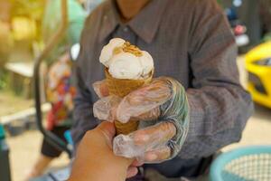 la glace crème vendeur, fait maison noix de coco Lait saveur, surmonté avec rôti cacahuètes délicieux, rafraîchissant à manger et cool bas. doux et sélectif se concentrer. photo