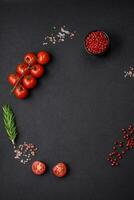 vide noir texture tableau, Cerise tomates sur une brindille, épices, sel et herbes photo