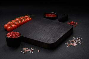 Ingrédients pour cuisine Cerise tomates, sel, épices et un vide Coupe planche photo