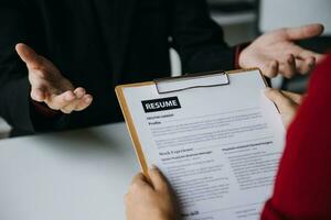 homme d'affaire ou emploi chercheur la revue le sien reprendre sur le sien bureau avant envoyer à découverte une Nouveau emploi avec stylo, cravate, des lunettes et numérique tablette. photo