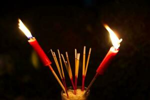 brûlant encens et rouge bougies à Payer hommage sur une foncé Contexte pendant faim fantôme Festival Payer hommage à leur décédé les ancêtres photo