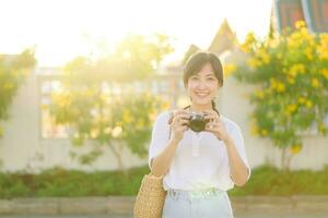 portrait de asiatique femme voyageur en utilisant caméra à rue de Bangkok, Thaïlande. Asie été tourisme vacances concept photo