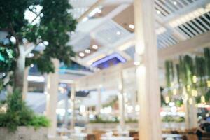 brouiller bokeh Contexte de intérieur table et chaise dans centre commercial cantine. abstrait bokeh de nourriture affaires à manger tribunal avec non personne. défocalisé de lumière vente au détail mode de vie café magasin décoration dans moderne. photo