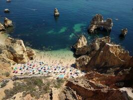 vue aérienne par drone de la plage animée de camilo à lagos, algarve, portugal pendant les vacances d'été. des destinations incroyables. voyage et aventure. vacances au bord de la mer. voyages exotiques. endroits les plus visités photo