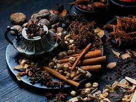 photo vue de dessus beaucoup d'ail, d'oignons, de poivrons, de piment et d'herbes séchées, ont été placés sur des assiettes et des tasses sur un fond de drak en bois noir. a été divisé pour se préparer à cuisiner des aliments indiens des aliments sains