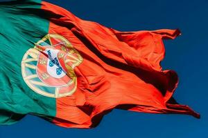 le Portugal drapeau isolé sur le bleu ciel agitant dans le vent photo