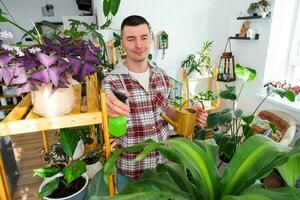 homme Vaporisateurs de une vaporisateur pistolet Accueil les plantes de sa collection, grandi avec l'amour sur étagères dans le intérieur de le maison. Accueil plante croissance, vert loger, l'eau équilibre, humidification photo