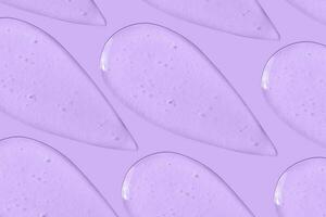 le Contexte est cosmétique. beaucoup frottis de transparent gel sur une violet Contexte. photo