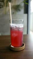 rouge la glace canneberge lever du soleil mocktail boisson consister de noir thé, canneberge, citron, menthe, et basilic graines. photo