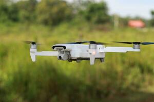 une photo de une drone en volant avec une floue hélice contre une vert ouvert espace Contexte. La technologie photo concept.