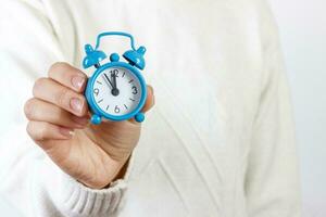 fille montrant un alarme l'horloge sur blanc Contexte photo