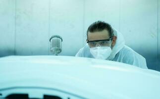 auto mécanicien dans voiture vaporisateur pièce inspecter le peindre pulvérisé dans le de face pare-chocs de le voiture cette le pigment est complet, beau, harmonieux avec le original Couleur de le voiture photo