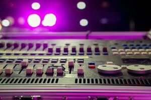 fermer et surgir de boutons avec bouton de du son la musique mixer contrôle panneau sur floue et bokeh de fête violet lumières et éclater Contexte. photo