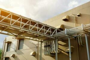 échappement et air Conditionneur conduits dans le tuyau pont pour soutien usine bâtiment sur bleu ciel avec des nuages et Soleil éclater Contexte. photo