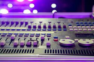 fermer et surgir de boutons avec bouton de du son la musique mixer contrôle panneau sur floue et bokeh de fête violet lumières et éclater Contexte. photo