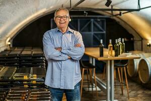 portrait de Sénior homme qui possède vignoble. il est examiner qualité dans le sien du vin cave. industrie du vin fabrication concept. photo