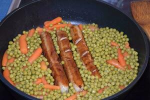 saucisses dans pois et carottes photo
