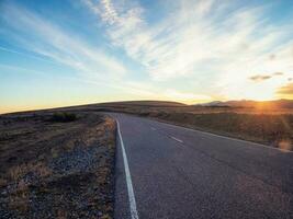 vide Montagne Autoroute à le coucher du soleil. asphalte route et ciel des nuages à coucher de soleil.route Contexte. photo