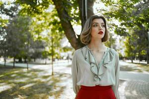 femme dans rouge jupe des promenades dans le parc des arbres mode de vie photo