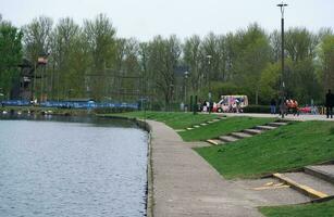 faible angle vue de volonté Lac parc avec local et touristique Publique profiter le beauté de Lac et parc par en marchant autour avec leur des familles. métrage a été capturé sur 09-avril-2023 à Milton Keynes Royaume-Uni photo