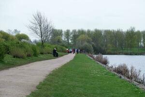 faible angle vue de volonté Lac parc avec local et touristique Publique profiter le beauté de Lac et parc par en marchant autour avec leur des familles. métrage a été capturé sur 09-avril-2023 à Milton Keynes Royaume-Uni photo