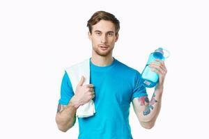 homme dans bleu T-shirt l'eau bouteille faire des exercices santé photo