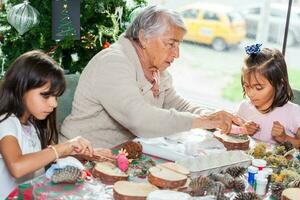 grand-mère enseignement sa petites filles Comment à faire Noël Nativité artisanat - réel famille photo