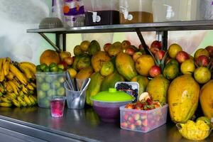 préparation de une traditionnel sucré l'eau la glace avec des fruits appelé cholado dans le ville de cali dans Colombie photo