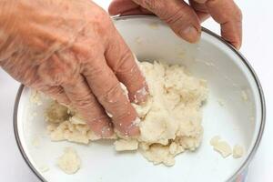 colombien arepa pâte préparation. pétrir par main le farine de maïs avec l'eau photo