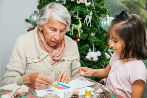 grand-mère enseignement sa petite fille Comment à faire Noël Nativité artisanat - réel famille photo