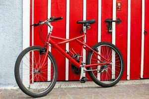 rouge vélo suivant à une rouge porte à le magnifique petit ville de Filandie dans le Région de quindio dans Colombie photo