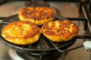 traditionnel colombien arepa de choclo préparation. blé pains étant rôti sur une rond gril photo