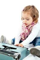 magnifique peu blond fille en jouant avec une machine à écrire photo