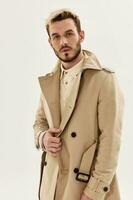 Beau homme dans manteau l'automne mode studio Regardez vers l'avant lumière Contexte photo